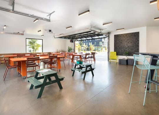 a room with tables and chairs and a chalkboard on the wall