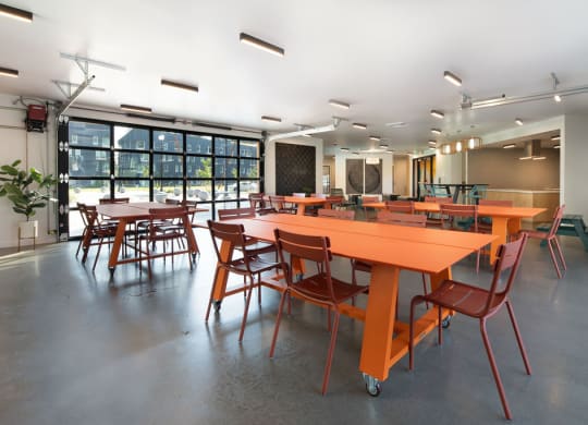 a large room with orange tables and chairs