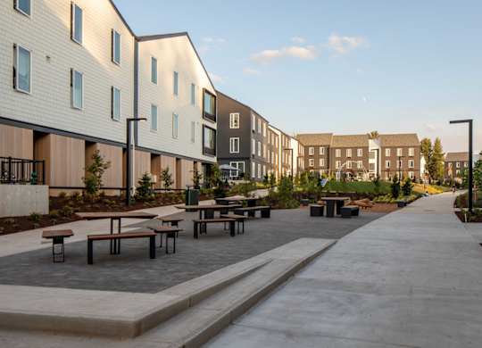 A long concrete walkway leads between two rows of modern buildings.