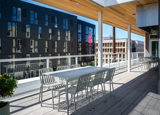 a patio with a table and chairs on a balcony at Slabtown Square Apartments, Portland , OR 97209