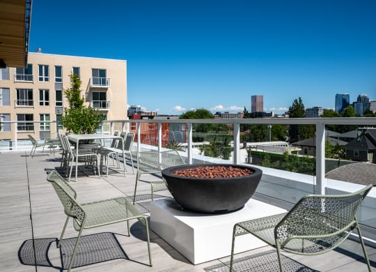 a fire pit on a rooftop terrace with chairs and tables at Slabtown Square Apartments, Oregon, 97209