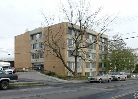 A large brick building with a tree in front of it.