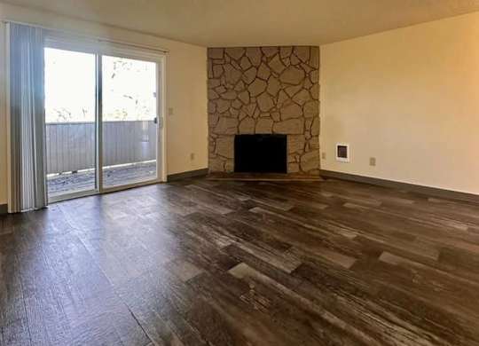 A room with a fireplace and sliding glass doors.