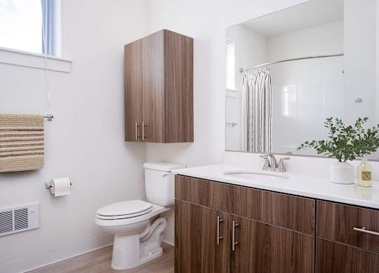 A white toilet sits next to a white sink in a bathroom.