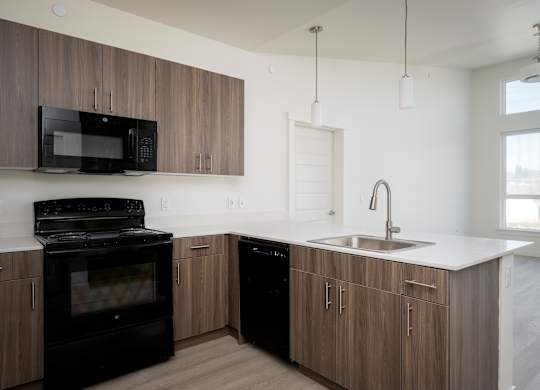 A modern kitchen with a black oven and microwave.