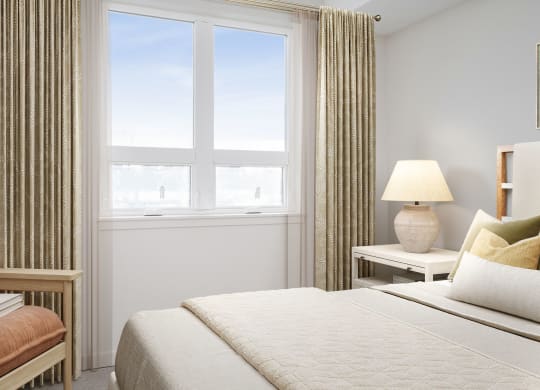 a bedroom with a large bed and a large window