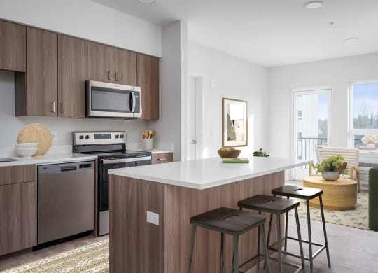 a kitchen with an island and stools in a 555 waverly unit
