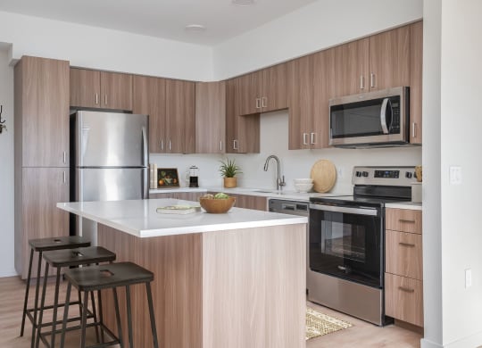 a kitchen with a large island and stainless steel appliances