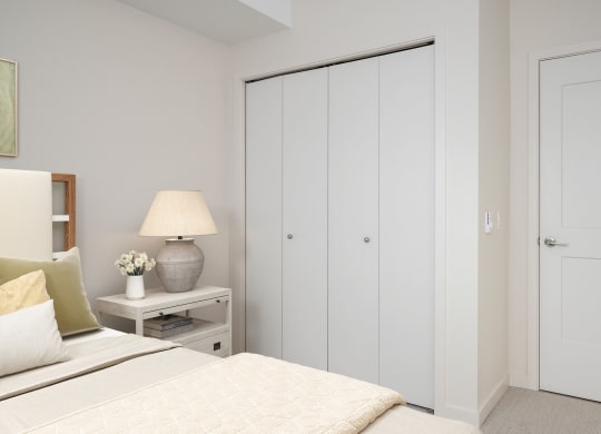 a bedroom with a bed and a nightstand with a lamp