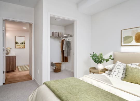 a bedroom with white walls and a green bedspread