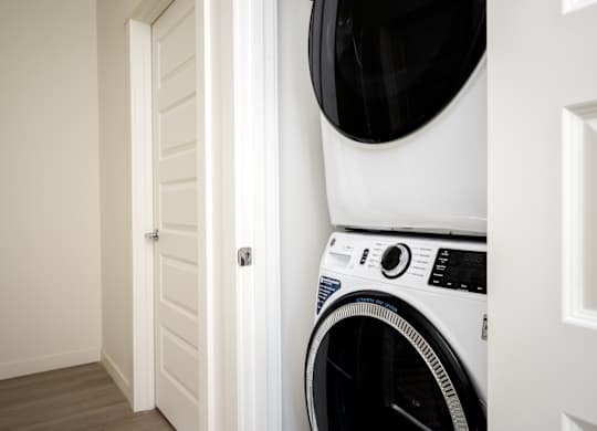 A white washing machine is placed in a corner of a room.