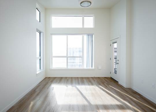 A room with a large window and wooden floors.