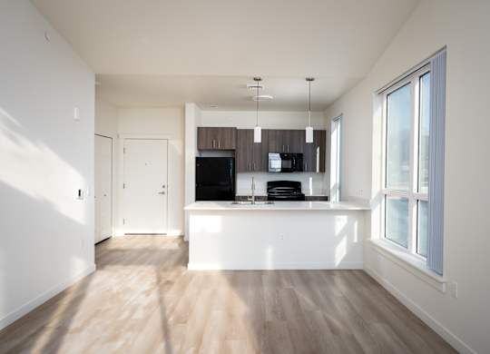 A modern kitchen with a wooden floor and white walls.