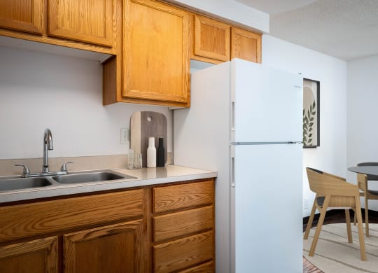 a kitchen with a sink and refrigerator and a dining room table