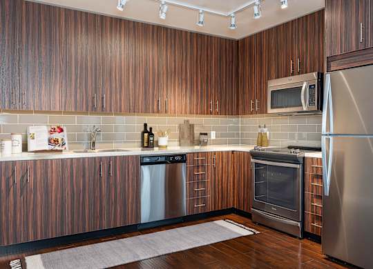 A modern kitchen with wooden cabinets and stainless steel appliances.