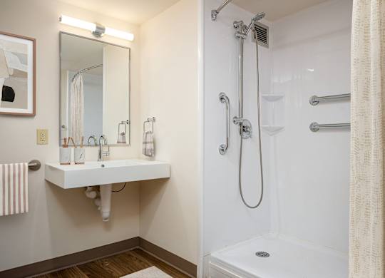 A white bathroom with a shower and sink.