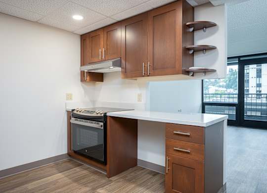 A kitchen with a white counter top and wooden cabinets.