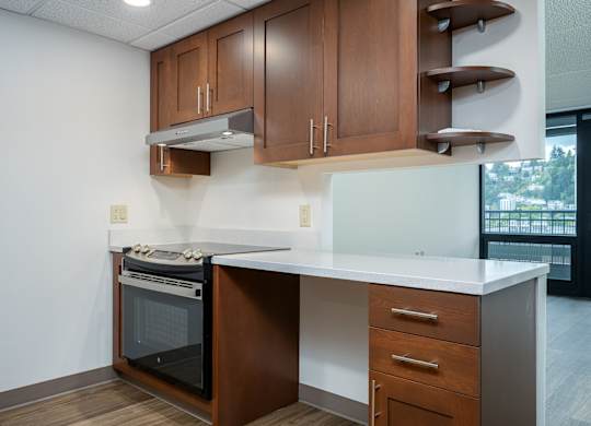 A kitchen with a white counter top and wooden cabinets.