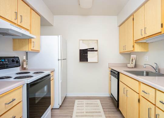 A kitchen with wooden cabinets and a white refrigerator.