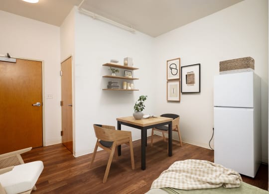 a small dining room with a table and chairs and a refrigerator