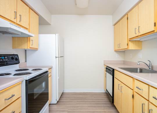A kitchen with wooden cabinets and a white refrigerator.