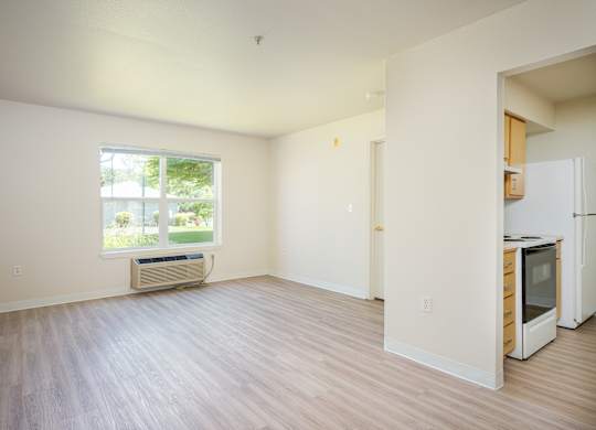 A room with a window and a white wall.