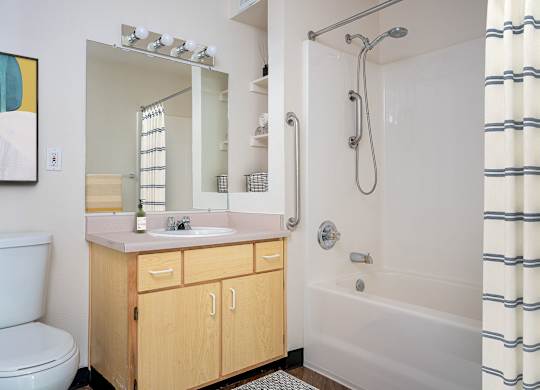 A bathroom with a toilet, sink, and shower.