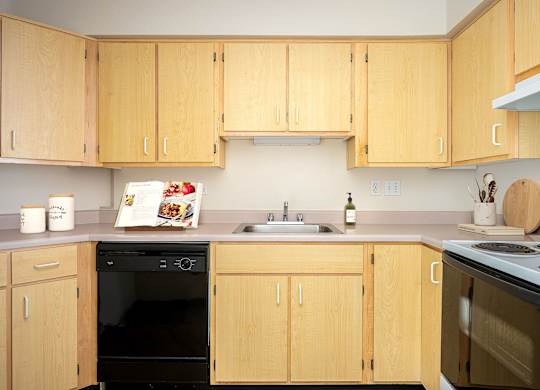 A kitchen with wooden cabinets and appliances.