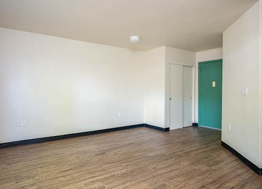 Empty room with wooden floor and white walls.
