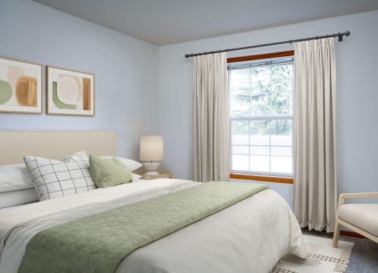 a bedroom with a bed and a chair in a room