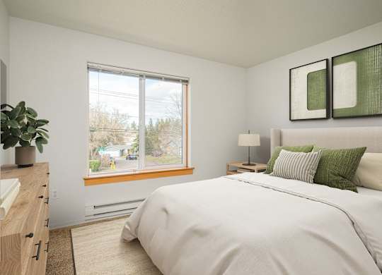 A bedroom with a large bed and a window overlooking a street.