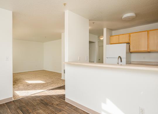 A kitchen area with wooden floors and white walls.