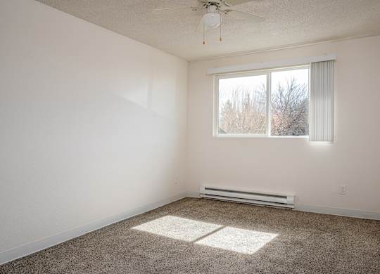 A room with a window and a ceiling fan.