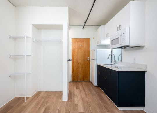 a kitchen with white walls and a wooden floor