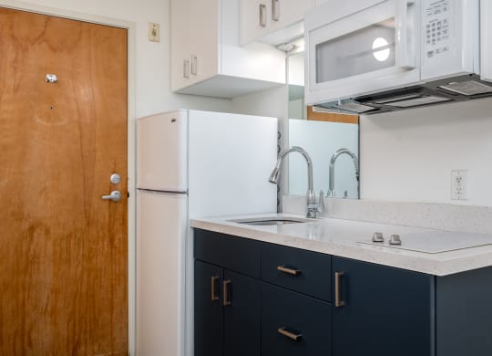 a kitchen with white appliances and black cabinets