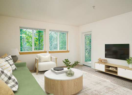 A living room with a green couch, a white chair, a round table, and a television.