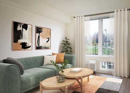 A living room with a green couch, a coffee table, and two abstract paintings on the wall.