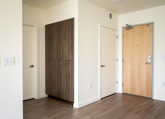an empty room with a wooden door and a closet