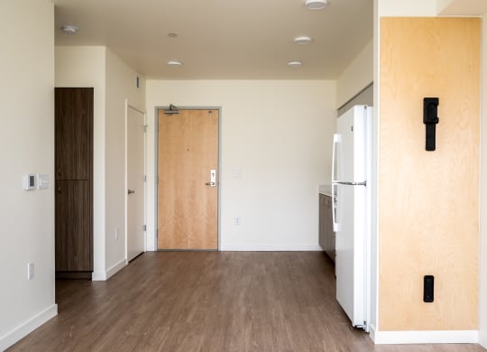 an empty room with a refrigerator and a door