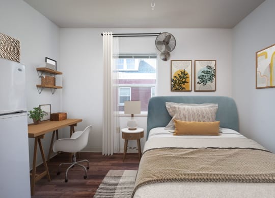 a bedroom with a bed and a desk and a window