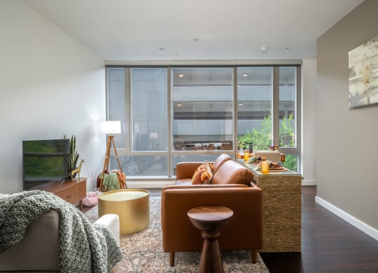 a living room with brown furniture and a large window
