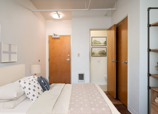 a bedroom with a bed and a closet and a door to a bathroom