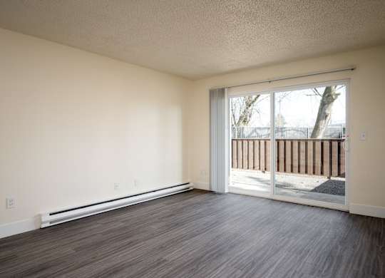 A room with a sliding glass door leading to a balcony.