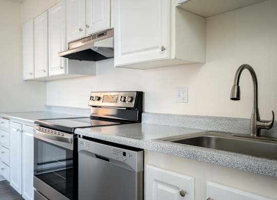 A modern kitchen with a stove, oven, and sink.