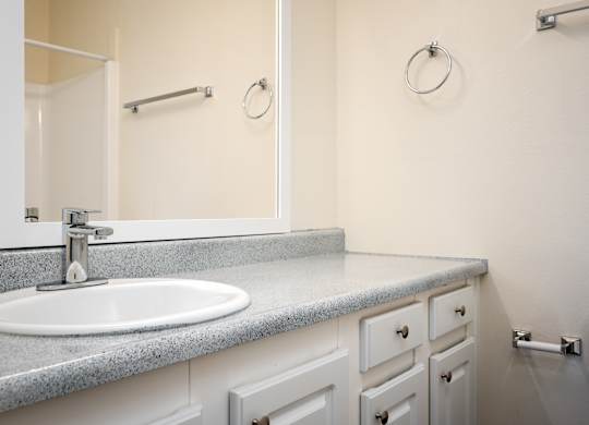 A bathroom with a sink, mirror, and toilet.