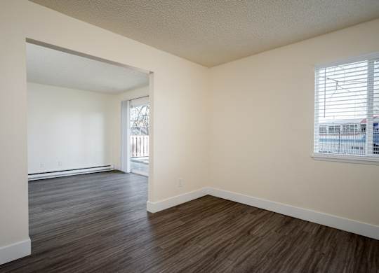 A room with a window and a door leading to a balcony.