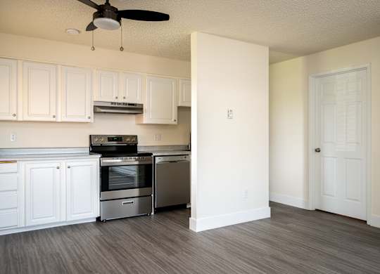 A kitchen with white cabinets and a stainless steel oven.