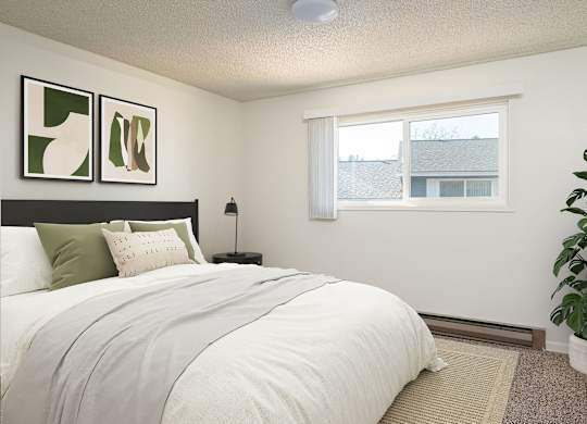 A bedroom with a large bed and a potted plant.