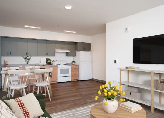 a living room and kitchen with a table and chairs and a television