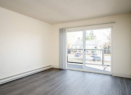A room with a sliding glass door leading to a parking lot.